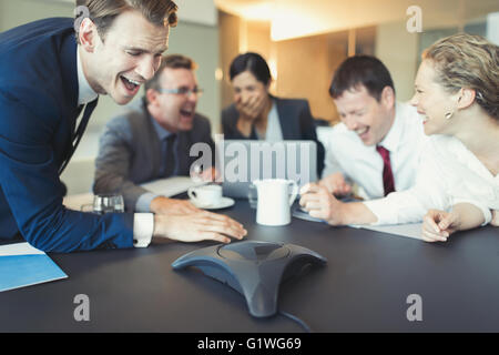 Laughing business people on conference call in conference room Stock Photo