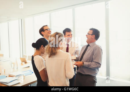 Laughing business people enjoying coffee break in conference room Stock Photo