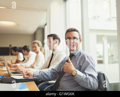 Portrait of confident businessman gesturing thumbs-up in conference room meeting Stock Photo