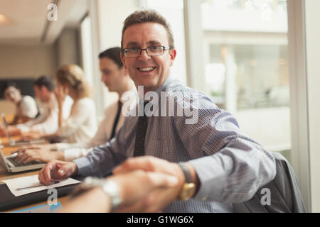 Portrait smiling businessman handshaking in conference room meeting Stock Photo