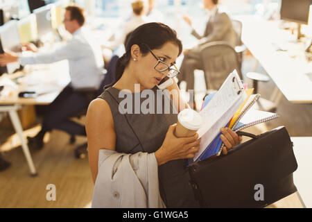 Stressed businesswoman struggling to multitask in office Stock Photo