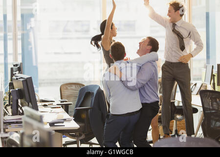 Exuberant business people celebrating and jumping in office Stock Photo