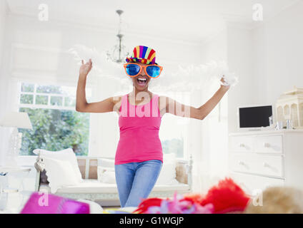 Portrait enthusiastic mature woman wearing feather boa and large sunglasses Stock Photo