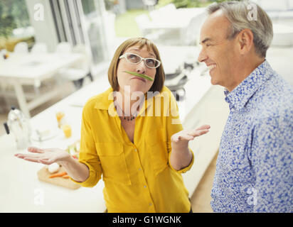 Playful mature woman with green bean mustache Stock Photo