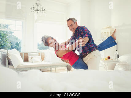 Playful mature couple dancing in living room Stock Photo