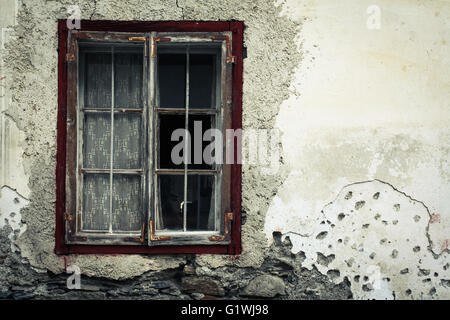 Rusty window on an old cracked concrete wall Stock Photo