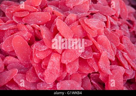 Heap of candied and dried tasty papaya slices with sugar for retail sale in food market. Stock Photo