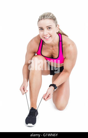 Female athlete tying her shoelace Stock Photo