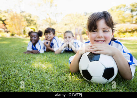 Close up view of girl lying on the floor with her soccer team Stock Photo