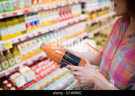 Close up view of woman choosing a bottle of fruits juice Stock Photo