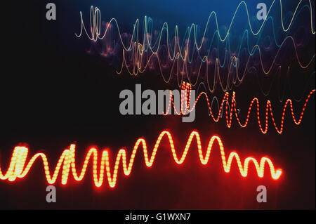 Overlaying wavy lines forming an abstract pattern on a dark background. Stock Photo