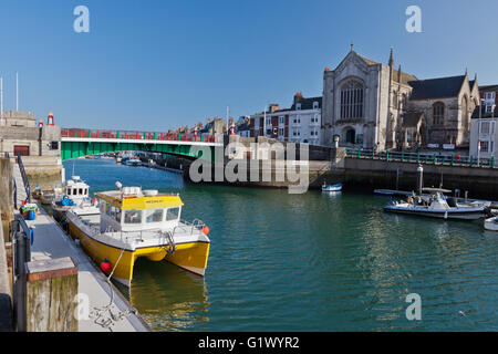 Two colourful fishing boats are moored adjacent to the Town Bridge in Weymouth harbour, Dorset, England, UK Stock Photo
