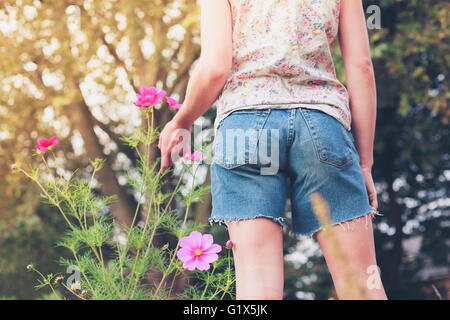 A young woman is picking flowers in a meadow during summer