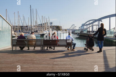 people sit on a bench and look at the water. Stock Photo