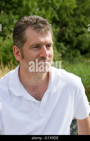 45-year old man with stubble enjoying a sunny summer vacation day in nature Stock Photo