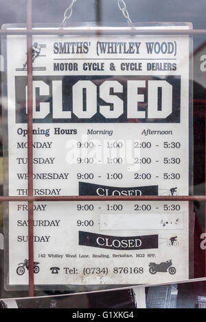 Closed sign on shop door with opening hours. Stock Photo