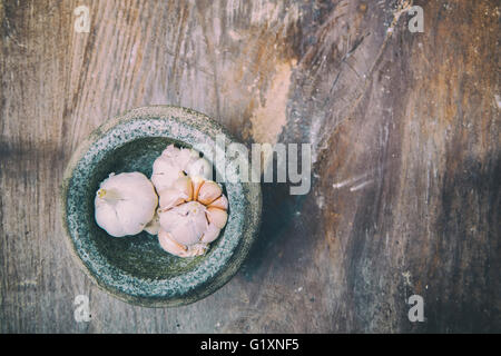 Soft Image of the garlic and stone mortar on old wooden. Stock Photo