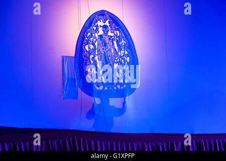 RATCHABURI THAILAND - APRIL 14, 2015: The Cowskin shows a man holding a stencil pattern. Moving Cowskin the light to shadow play Stock Photo