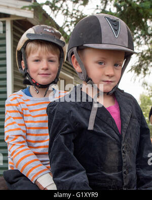 Selfoss, South Iceland, Iceland. 4th Aug, 2015. Two young boys atop their steeds at the Fridheimar family run farm in Selfoss, South Iceland. Besides horticulture, the family offers visitors a horse show featuring the Icelandic horse breed brought by the first settlers from Scandinavia around 900 AD. Tourism is a growing sector of the economy with Iceland becoming a favorite tourist destination. © Arnold Drapkin/ZUMA Wire/Alamy Live News Stock Photo