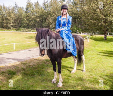 Selfoss, South Iceland, Iceland. 4th Aug, 2015. At the Fridheimar family run farm in Selfoss, South Iceland, a young girl poses atop her horse. Besides horticulture, the family offers visitors a horse show introducing the Icelandic horse breed brought by the first settlers from Scandinavia around 900 AD. Tourism is a growing sector of the economy with Iceland becoming a favorite tourist destination. © Arnold Drapkin/ZUMA Wire/Alamy Live News Stock Photo