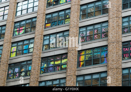Colourful pixel art made from sticky notes by employees in the windows of rival office buildings on Canal Street, New York City Stock Photo