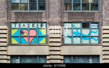 Colourful pixel art made from sticky notes by employees in the windows of rival office buildings on Canal Street, New York City Stock Photo