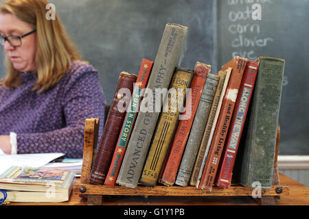 Miles, Iowa, USA. 19th May, 2016. Old school books sit on Heidi Lippens desk during the fourth-grade class spent the day at the old Teeds Grove No. 3 School in Miles, Iowa Thursday, May 19, 2016. Credit:  Quad-City Times/ZUMA Wire/Alamy Live News Stock Photo