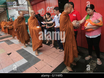 Magelang, Indonesia. 21st May, 2016. Buddhist monks collect alms from Buddhist followers ahead of Vesak Day in Magelang, Indonesia, May 21, 2016. Vesak Day, also known as the Buddha Day, will be celebrated on May 22 in Indonesia. Credit:  Tri H./Xinhua/Alamy Live News Stock Photo