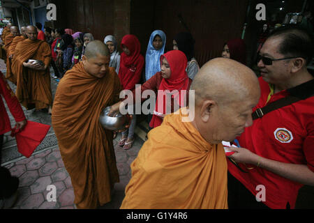 Magelang, Indonesia. 21st May, 2016. Buddhist monks collect alms from Buddhist followers ahead of Vesak Day in Magelang, Indonesia, May 21, 2016. Vesak Day, also known as the Buddha Day, will be celebrated on May 22 in Indonesia. Credit:  Tri H./Xinhua/Alamy Live News Stock Photo