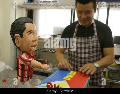 Quezon City, Philippines. 21st May, 2016. Bakeshop owner Tristan Carlos puts some finishing touches on a cake featuring presumptive Philippine president-elect Rodrigo Duterte at a bakeshop in Quezon City, the Philippines, May 21, 2016. The cake is made to celebrate a large portion of almost 16 million votes Rodrigo Duterte won during the Philippine presidential election. © Rouelle Umali/Xinhua/Alamy Live News Stock Photo