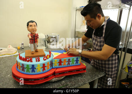 Quezon City, Philippines. 21st May, 2016. Bakeshop owner Tristan Carlos puts some finishing touches on a cake featuring presumptive Philippine president-elect Rodrigo Duterte at a bakeshop in Quezon City, the Philippines, May 21, 2016. The cake is made to celebrate a large portion of almost 16 million votes Rodrigo Duterte won during the Philippine presidential election. © Rouelle Umali/Xinhua/Alamy Live News Stock Photo