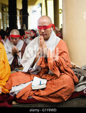 A monk prays during a Tibetan Chenrezig Initiation by His Holiness the Dalai Lama at Tsuglagkhang Temple, in McLeod Ganj, India. Stock Photo