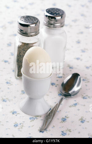 Egg cup with an egg with spoon, salt and pepper shakers Stock Photo