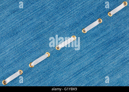 Fashionable background, white satin ribbon inserted in denim, with space for your creativity Stock Photo