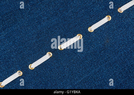 Fashionable background, white satin ribbon inserted in denim, with space for your creativity Stock Photo