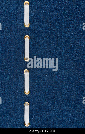 Fashionable background, white satin ribbon inserted in denim, with space for your creativity Stock Photo