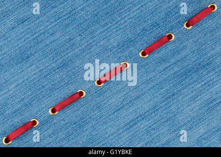 Fashionable background red satin ribbon inserted in denim, with space for your creativity Stock Photo