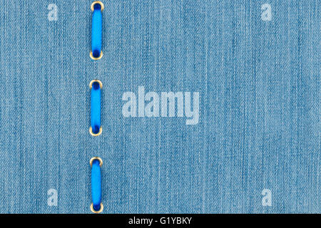 Fashionable background, blue satin ribbon inserted in denim, with space for your creativity Stock Photo