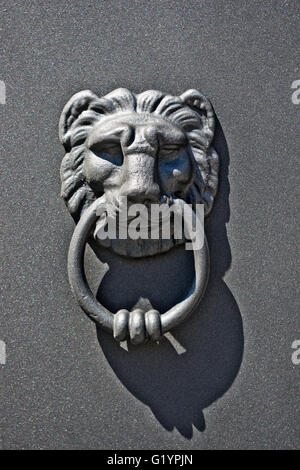 door knocker with bright iron lion in the sun Stock Photo