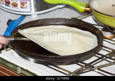 cooking flour pancakes on a black cast iron skillet Stock Photo