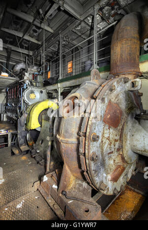 The ship's hold with diesel engine mounted on ship. Engine room on a old cargo boat ship. Stock Photo