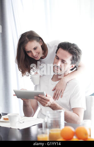 Couple having breakfast at home and using tablet Stock Photo