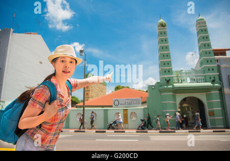 Happy Asia woman Travel in Singapore, Pointing Masjid Jamae Stock Photo