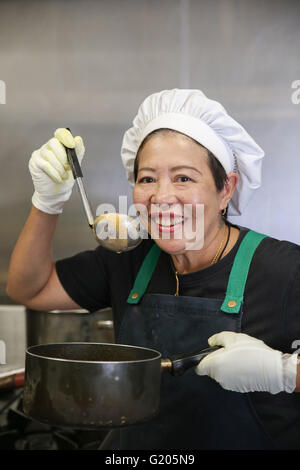 Asian woman chef in kitchen Stock Photo