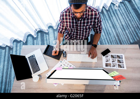 Overhead view of casual man working at desk Stock Photo