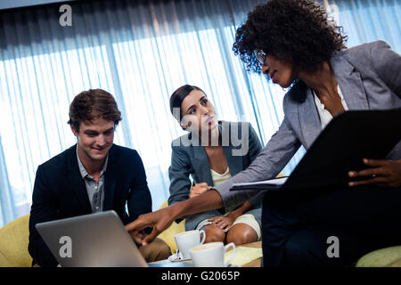 Coworkers having meeting around table Stock Photo