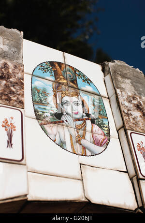 Iconography of the Hindu God Krishna playing a flute adorns a roadside water well in McLeod Ganj, Dharamsala, India. Stock Photo