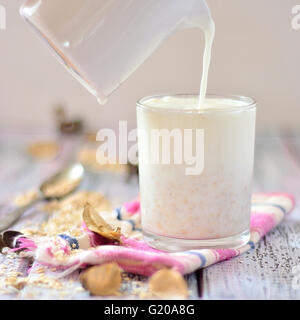 Oat milk in a glass on the table with fruit Stock Photo