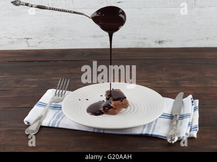 Hot melted chocolate pouring from vintage silver spoon onto a cookie Stock Photo