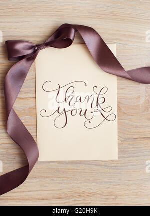 close up of card note with brown ribbon and words thank you Stock Photo